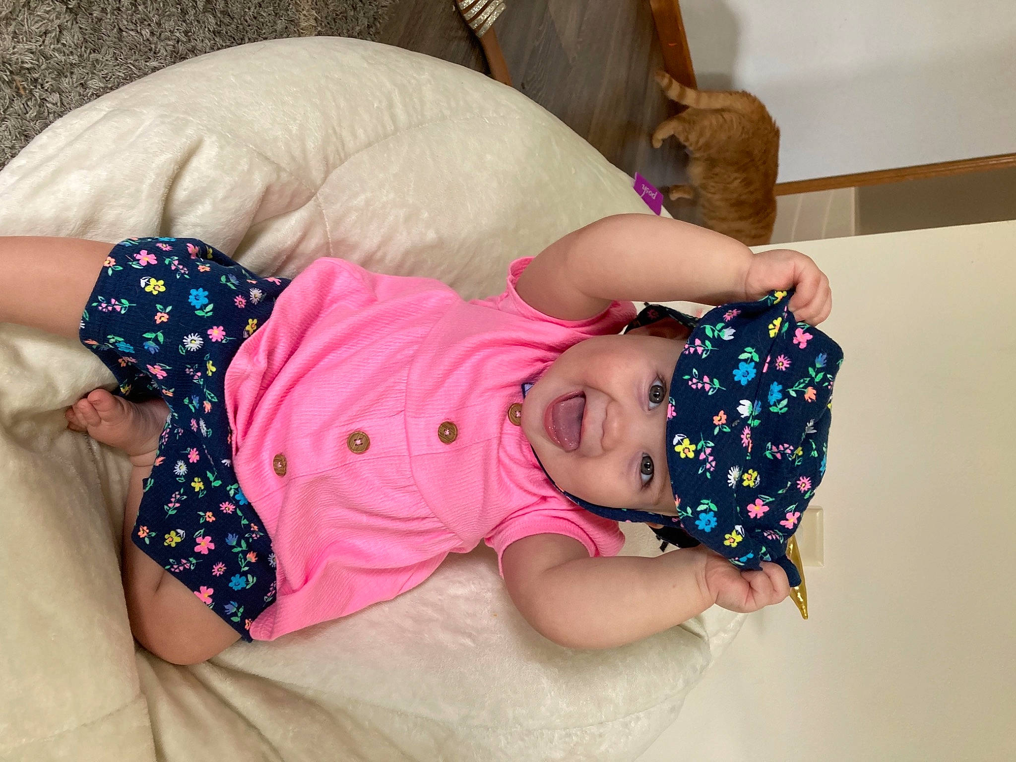 Brynn is registered to the contest to win money with this photo: abdomen, baby, baby_sleeping, baby_toddler_clothing, child, comfort, fun, glasses, happy, headwear, human_body, human_leg, linens, magenta, nail, pattern, person, pink, sleeve, thigh