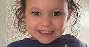 Novaleigh joined the competition — help win amazing prizes! child, toddler, curly_hair, pigtails, smiling, blue_shirt, text_on_clothing, indoor, portrait, face, happy, person, casual_clothing, cute, young_child, head, eyes, skin, hair, expression