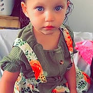 Novaleigh joined the competition — help win amazing prizes! toddler, child, baby, blue_eyes, sitting, dress, floral_pattern, green_top, indoor, bed, laundry_basket, hair, face, expression, skin, clothing, person, cute, portrait, text_overlay