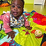 baby, child, dribble, playmat, colorful, indoor, toy, happy, crawling, clothing, patterned, face, hand, floor, expression, person, curly_hair, smiling, infant, bright