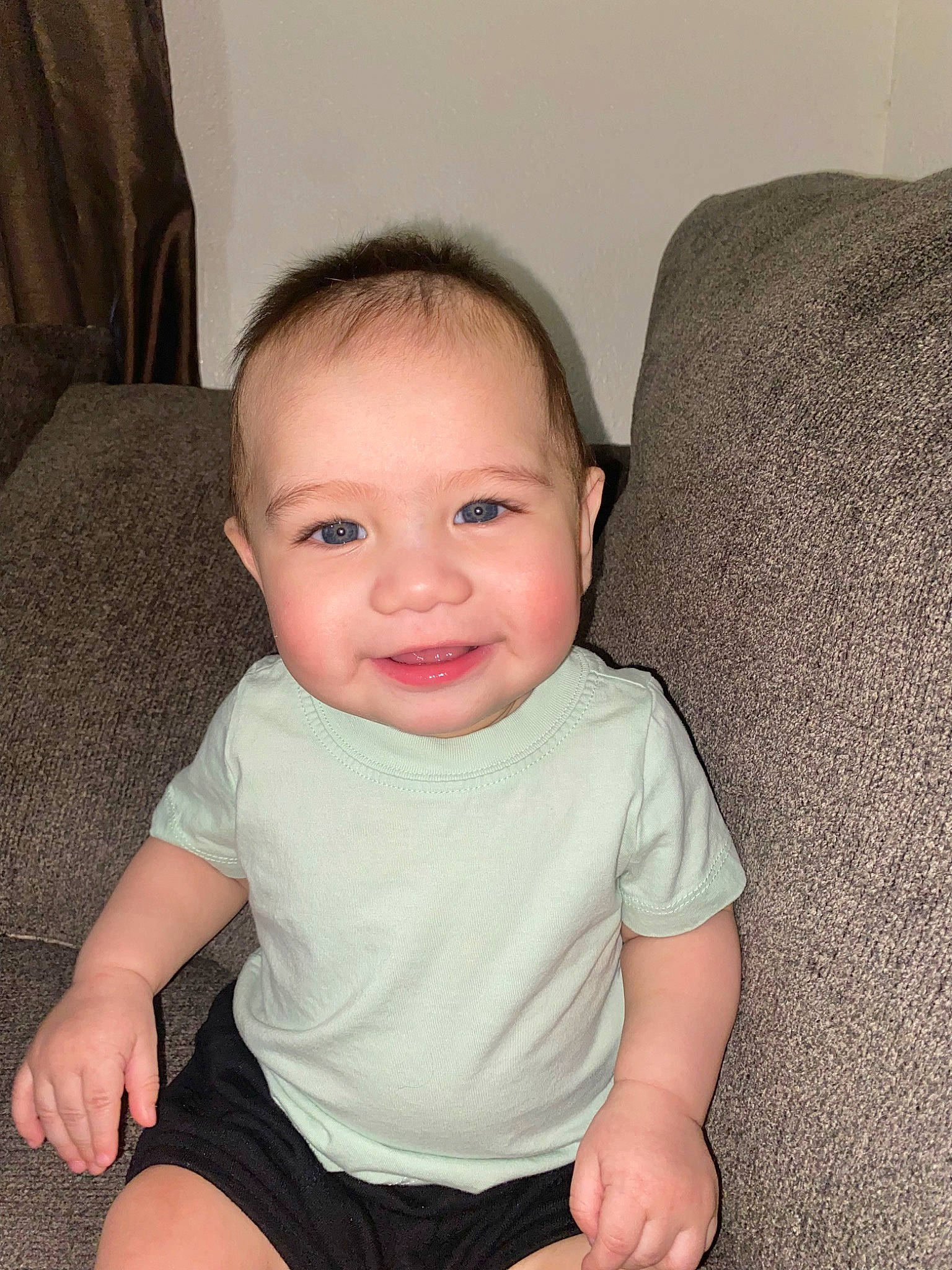 Azaiah is registered to the contest to win money with this photo: baby, baby_toddler_clothing, cheek, comfort, couch, eyebrow, face, finger, flooring, head, human_body, human_leg, joy, neck, nose, person, sitting, skin, sleeve, smile