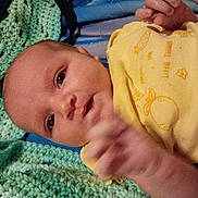 Lakota joined the competition — help win amazing prizes! baby, infant, yellow_onesie, crocheted_blanket, blue_blanket, green_blanket, hand, face, eyes, skin, lying_down, curious, cute, newborn, child, indoors, soft_texture, fabric, portrait, person