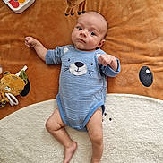Arthur a rejoint le concours — aidez-le/la à gagner de superbes lots ! baby, infant, blue_onesie, plush_toy, giraffe_toy, animal_blanket, floor, wooden_floor, baby_piano, child, cute, lying_down, soft_texture, indoors, playtime, toy, small_foot, face, expression, comfortable