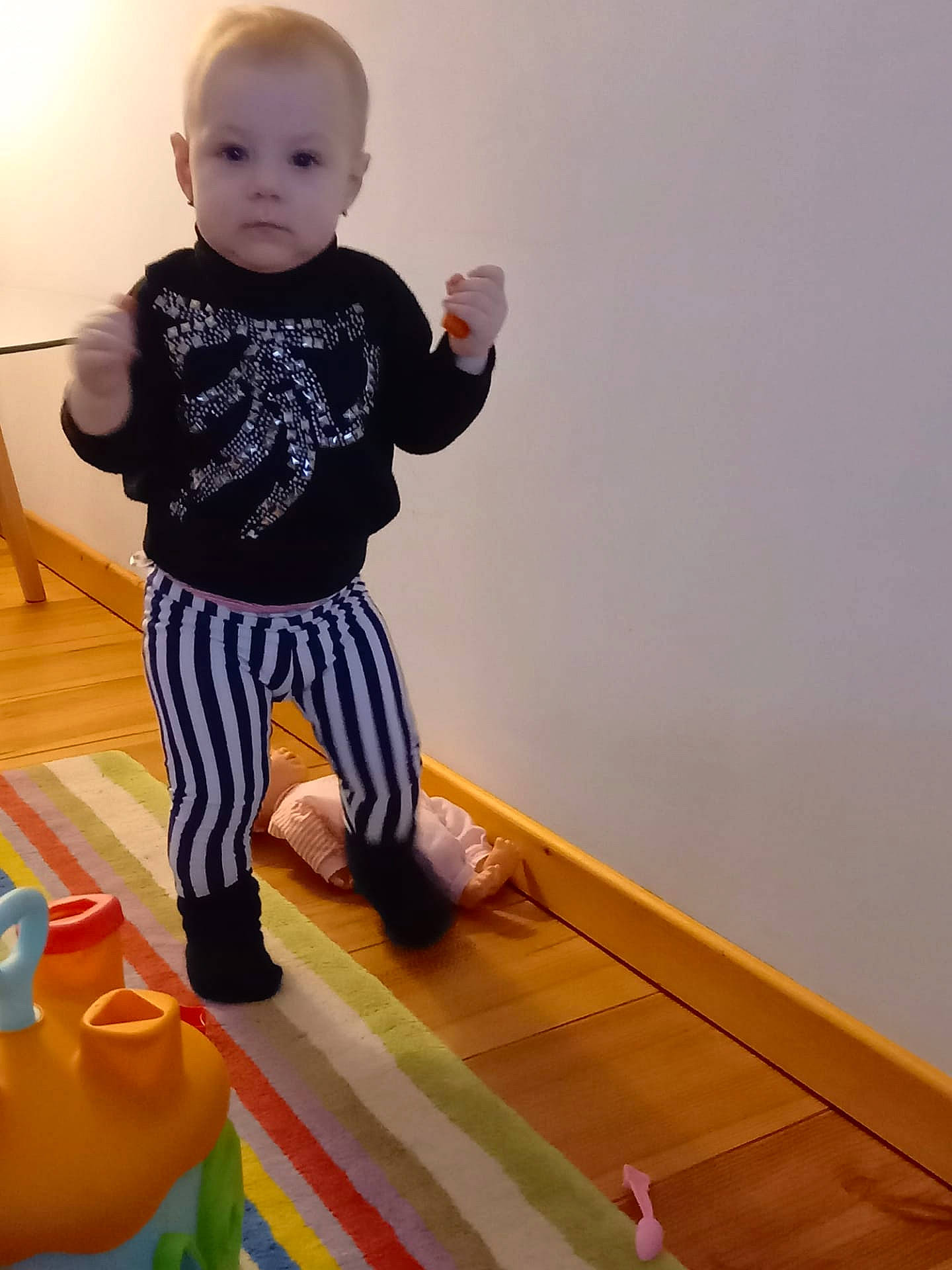 Elodie participe au concours pour gagner de l'argent avec cette photo : baby, baby_playing_with_toys, baby_toddler_clothing, child, floor, flooring, fun, happy, hardwood, head, knee, leg, pattern, person, sitting, sleeve, sportswear, t_shirt, toddler, toy