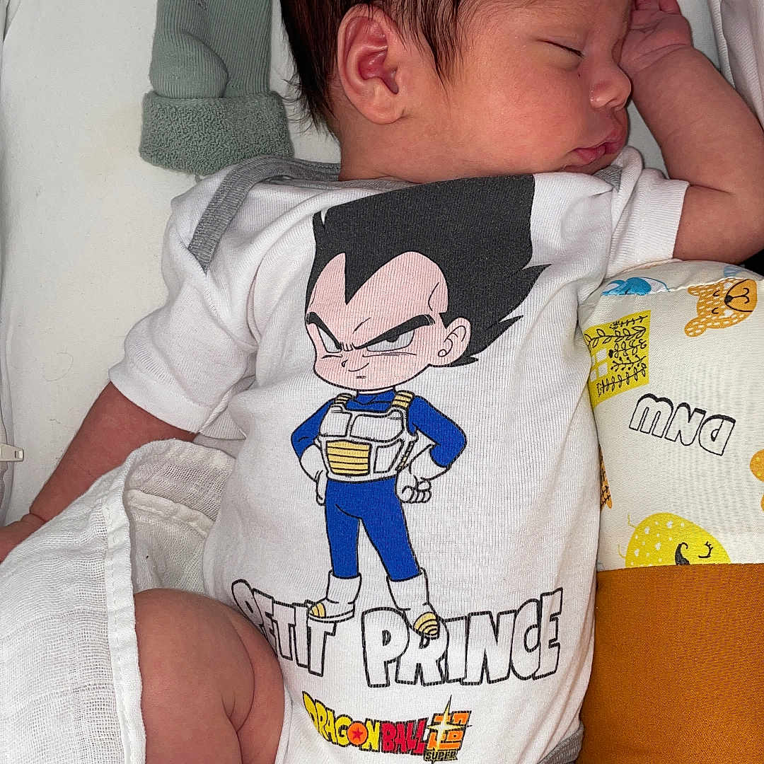 Jackson a rejoint le concours — aidez-le/la à gagner de superbes lots ! baby, blanket, character_print, child, clothing, cute, dragon_ball, indoors, infant, laying_down, mittens, newborn, onesie, peaceful, person, pillow, resting, sleep, sleeping, soft