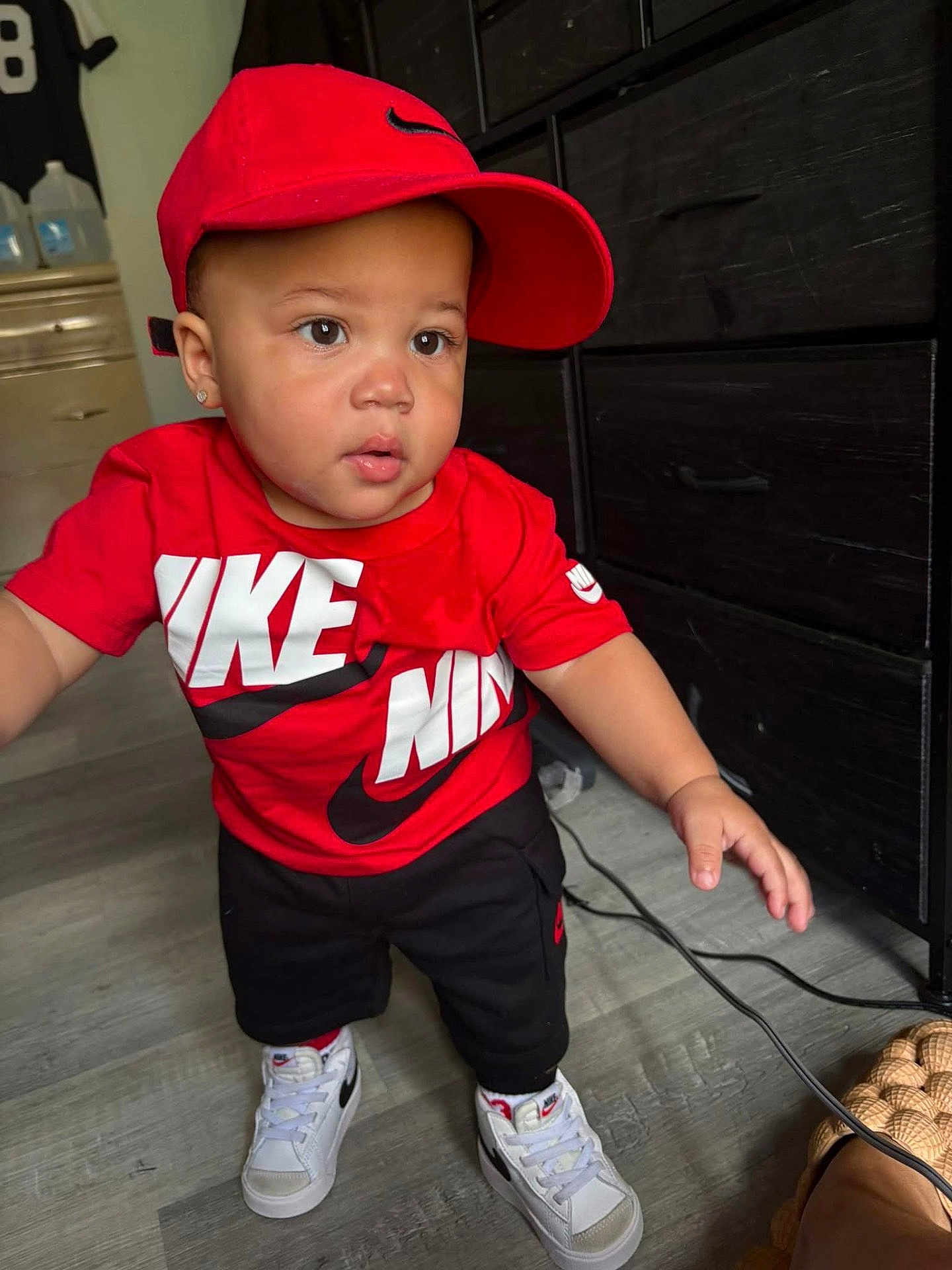 Xykie joined the competition — help win amazing prizes! toddler, child, nike, red_cap, red_shirt, black_pants, white_sneakers, indoor, flooring, furniture, drawer, earring, curious, standing, person, portrait, casual_clothing, baby, young_child, fashion
