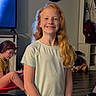 child, indoor, table, cards, remote_control, glasses, red_hair, smiling, playful, background, furniture, person, clothing, hair, toy, cup, sitting, game, room, home