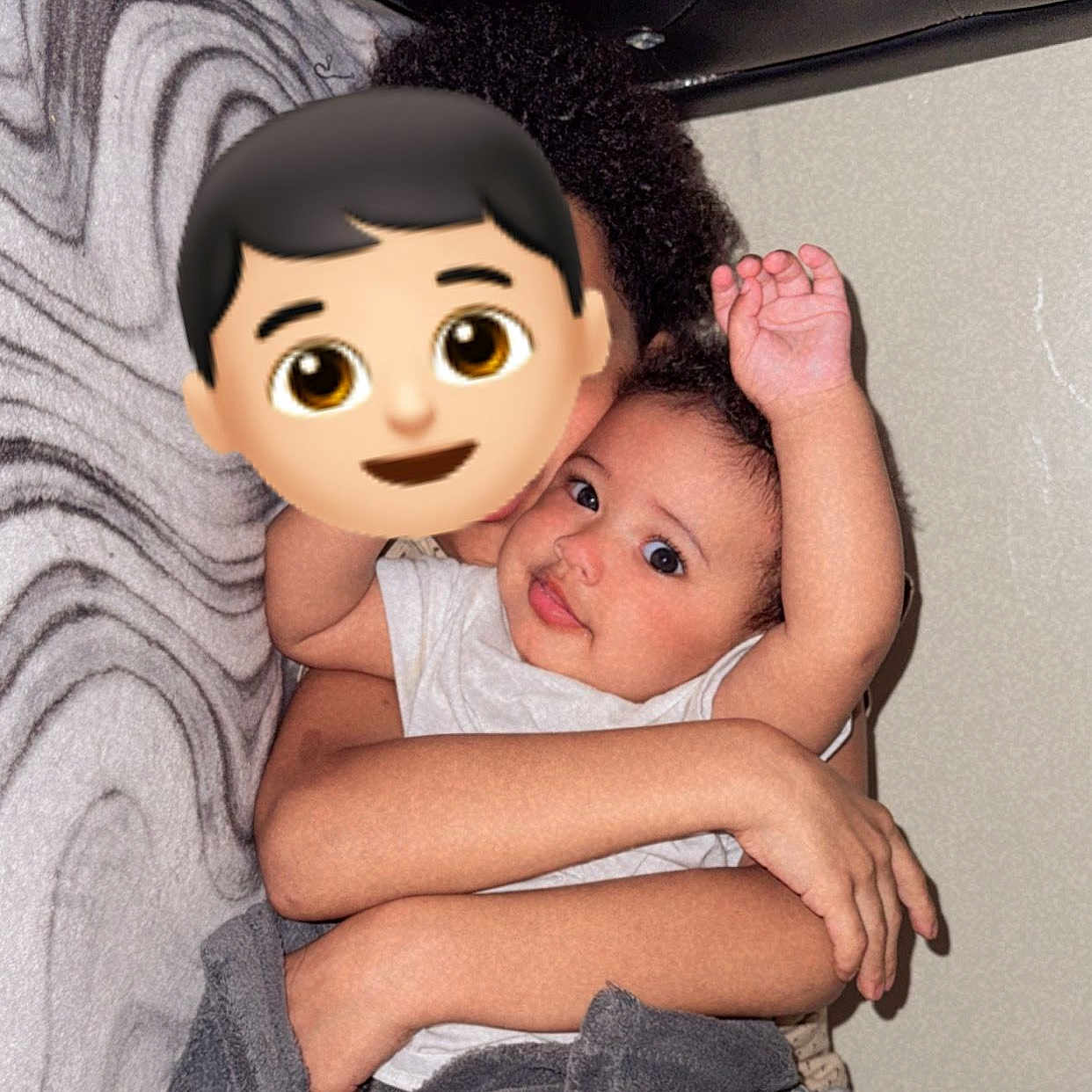 Christ is registered to the contest to win money with this photo: arm, baby, blanket, child, clothing, comfort, cuddle, expression, face, hair, holding, hug, indoor, pattern, person, sitting, skin, smile, toddler, wall