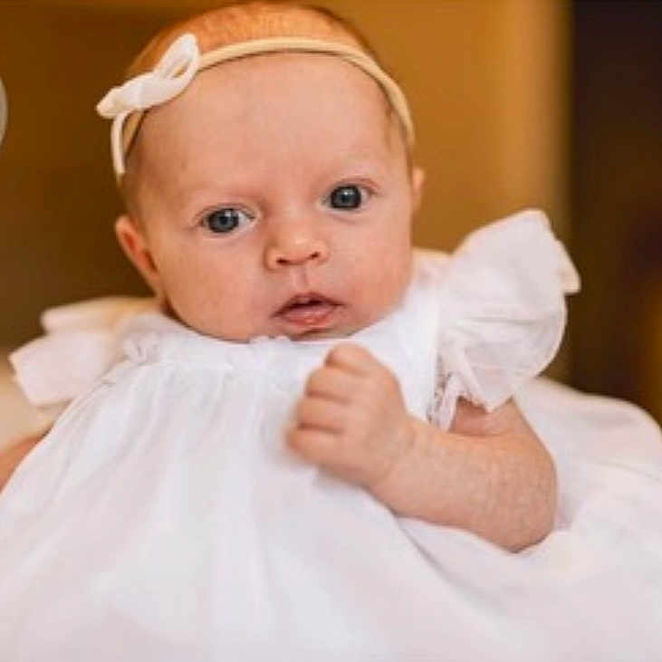 Alaska joined the competition — help win amazing prizes! accessories, arm, baby, biting, blonde, bodypart, clothing, face, finger, frown, hair, hand, head, headband, newborn, people, person, photography, portrait, sad