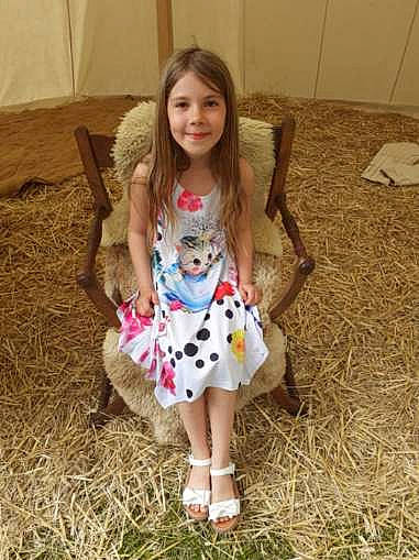 Inaya a rejoint le concours — aidez-le/la à gagner de superbes lots ! baby_toddler_clothing, brown_hair, chair, doll, dress, eye, face, fawn, flooring, grass, hair, head, joy, pattern, person, plant, skin, sleeve, smile, t_shirt