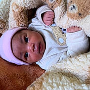 Neoentle is registered to the contest to win money with this photo: baby, blanket, pink_hat, teddy_bear_pattern, cozy, warm, soft_texture, infant, cute, wrapped, clothing, sleepwear, closeup, skin, face, hands, lying_down, comfort, indoor, portrait