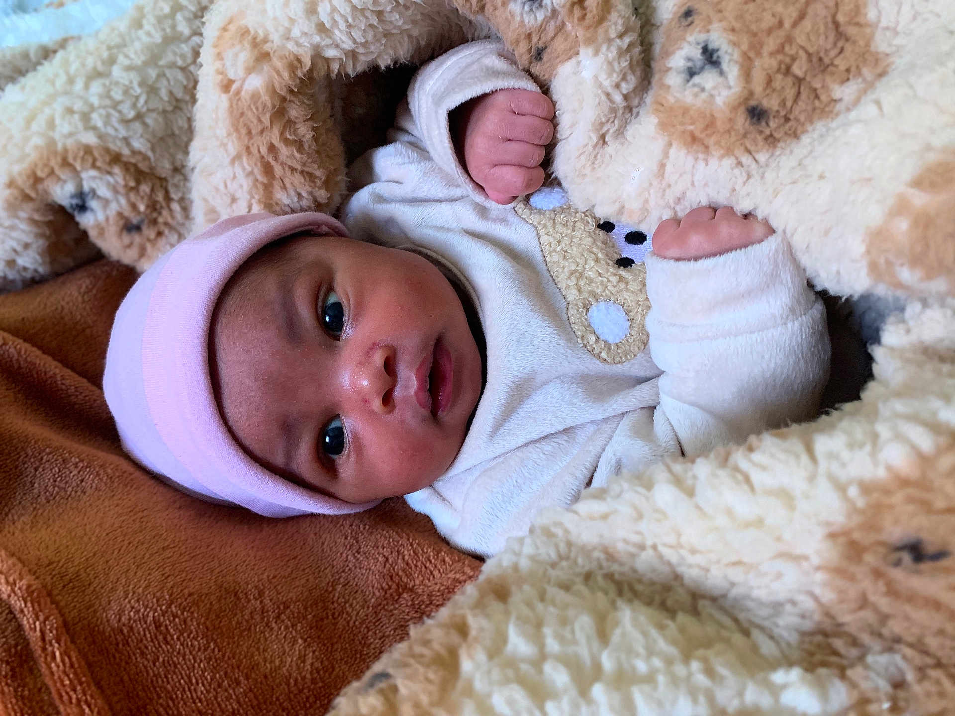 Neoentle is registered to the contest to win money with this photo: baby, blanket, pink_hat, teddy_bear_pattern, cozy, warm, soft_texture, infant, cute, wrapped, clothing, sleepwear, closeup, skin, face, hands, lying_down, comfort, indoor, portrait