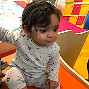 Nélia participe au concours pour gagner de l'argent avec cette photo : toddler, child, indoor, pajamas, sitting, orange_chair, curly_hair, portrait, furniture, window, colorful, playroom, smiling, baby, cute, young_child, person, expression, casual_clothing, daylight