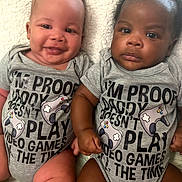 Keith And Keion joined the competition — help win amazing prizes! baby, infant, toddler, smiling, serious, onesie, clothing, gray, text, video_games, controller, cute, sitting, blanket, indoors, two_babies, diversity, portrait, holding_hands, closeup