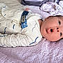 Enzo is registered to the contest to win money with this photo: baby, infant, onesie, blanket, face, expression, mouth_open, lying_down, newborn, clothing, soft_texture, bedroom, cute, child, person, sleepwear, indoor, skin, head, young