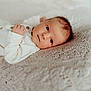 baby, newborn, infant, lying_down, blanket, knitted, texture, soft_lighting, neutral_colors, portrait, close_up, cute, sleepwear, small_hands, face, head, eyes, skin, peaceful, indoor