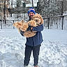Bodie joined the competition — help win amazing prizes! man, dog, snow, winter_clothing, beanie, gloves, boots, outdoor, trees, fence, smiling, curly_fur, pet, playful, cold_weather, nature, portrait, happy, standing, holding