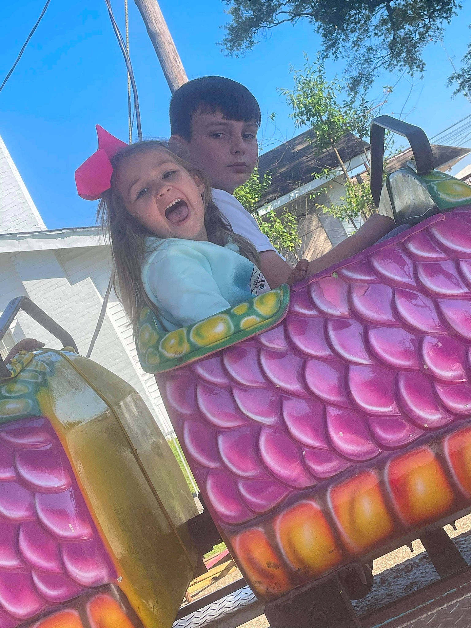 Courtney is registered to the contest to win money with this photo: amusement_park, city, event, fun, human_body, human_settlement, leisure, magenta, nonbuilding_structure, outdoor_play_equipment, person, pink, playground, pole, public_space, purple, recreation, sky, smile, toddler