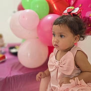 Alana Cobas is registered to the contest to win money with this photo: balloons, bow, celebration, child, curious, curly_hair, cute, decorations, earrings, festive, hair_clip, indoor, party, person, pink_dress, pink_tablecloth, portrait, table, toddler, young_child