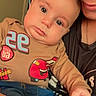 Zaylen joined the competition — help win amazing prizes! baby, infant, child, adult, portrait, selfie, smiling, wide_eyed, indoors, close_up, person, face, head, clothing, shirt, superhero, graphic_print, blue_pants, sitting, family