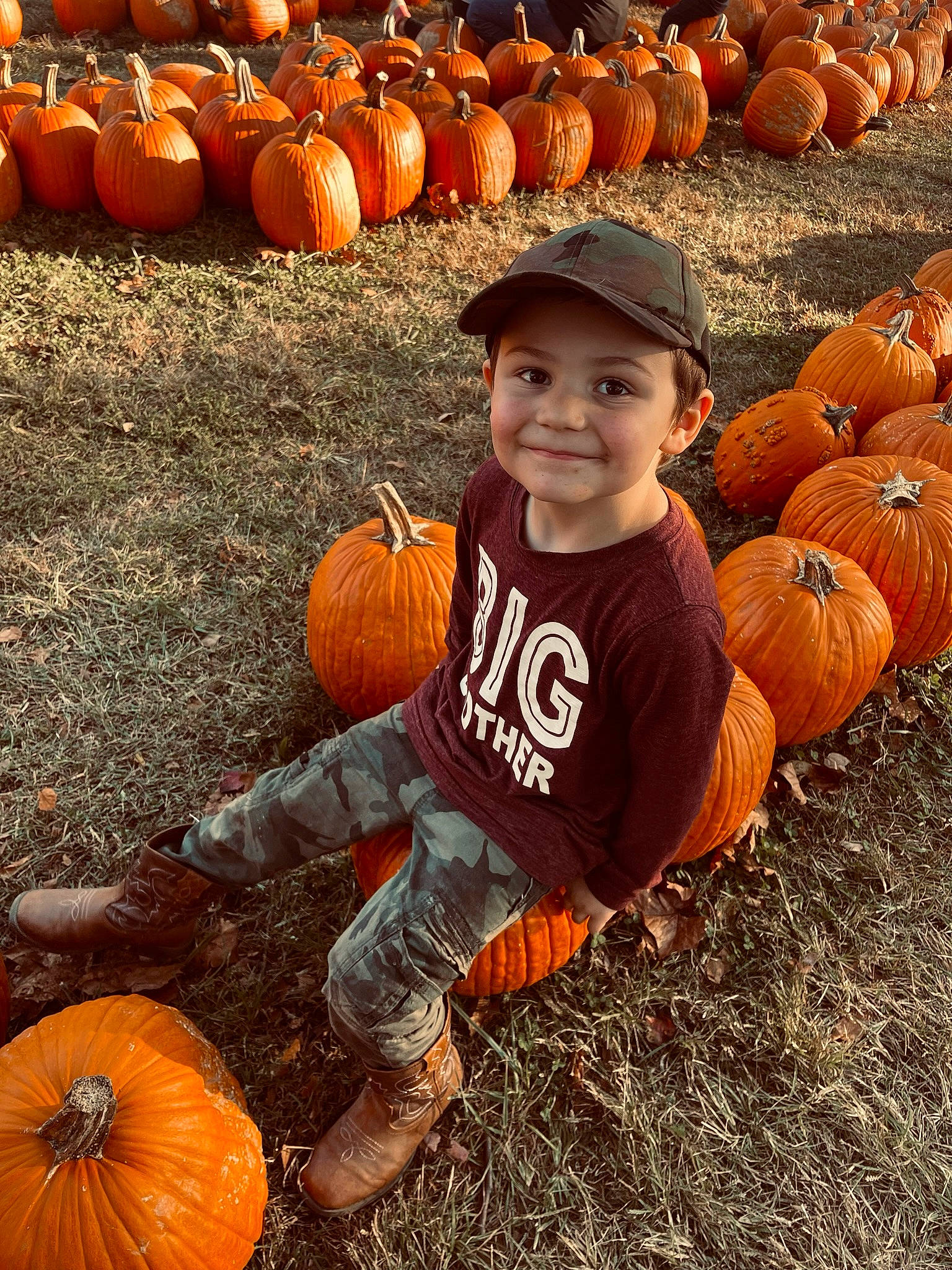 Brandon is registered to the contest to win money with this photo: agriculture, calabaza, cucurbita, gourd, grass, happy, hat, headwear, joy, local_food, natural_foods, orange, people, people_in_nature, person, photograph, plant, pumpkin, smile, squash