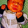 Emmanuel Malachi is registered to the contest to win money with this photo: baby, newborn, infant, clenched_fists, sleeping, puckered_lips, striped_clothing, zipper, blanket, green_background, portrait, cute, small, child, soft_lighting, indoors, red_text_overlay, humor, boxing_pose, closeup