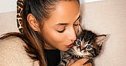 Plume participe au concours pour gagner de l'argent avec cette photo : woman, kitten, cat, tabby_cat, pet, kissing, affection, cuddling, holding, portrait, indoors, couch, blanket, sweater, scarf, hair_bow, blue_eyes, cozy, framed_art, home_decor
