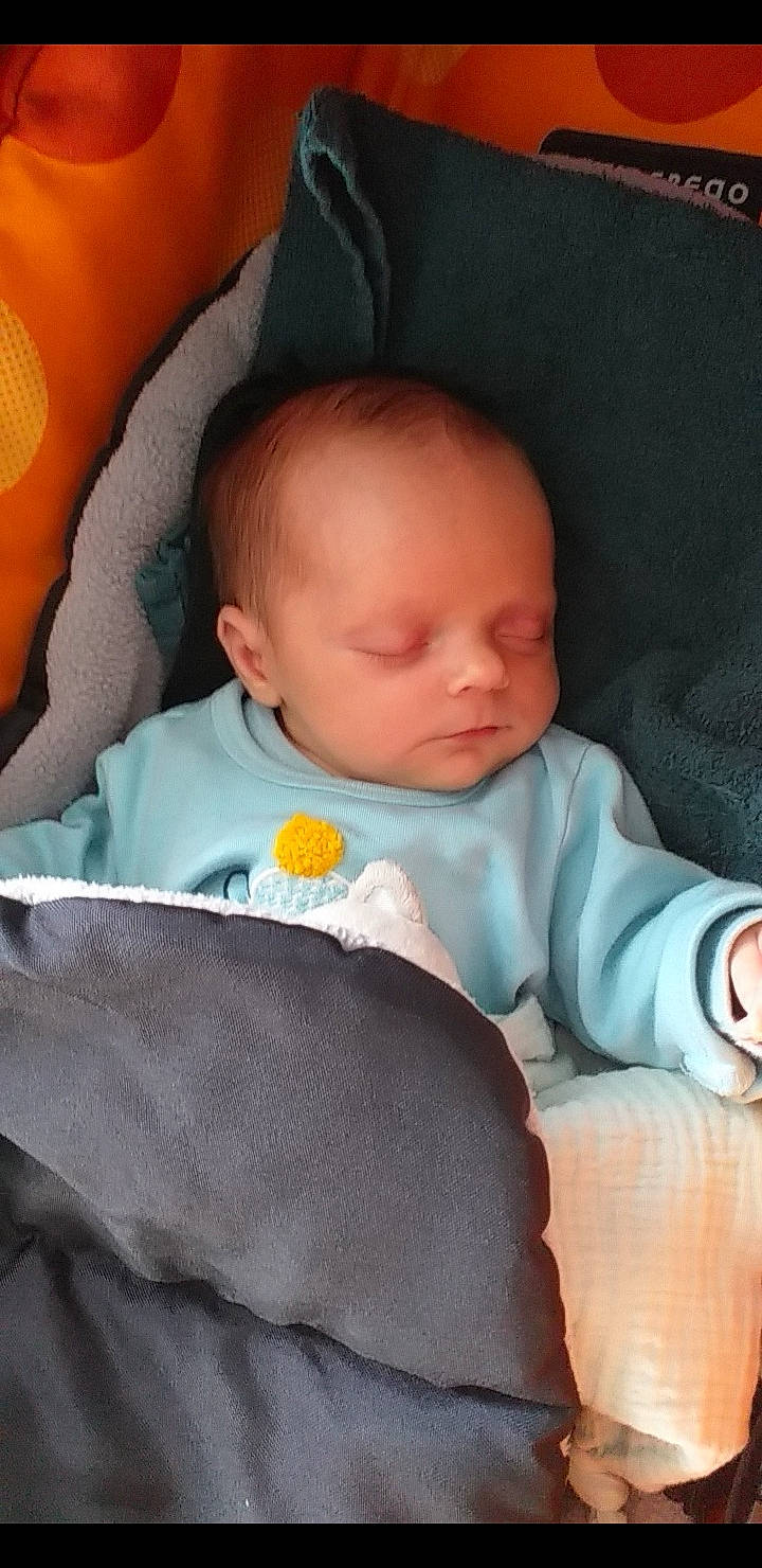 Lëlio participe au concours pour gagner de l'argent avec cette photo : baby, baby_products, baby_sleeping, baby_toddler_clothing, bedtime, cheek, child, chin, comfort, iris, linens, nose, orange, person, product, room, sitting, skin, sleeve, textile