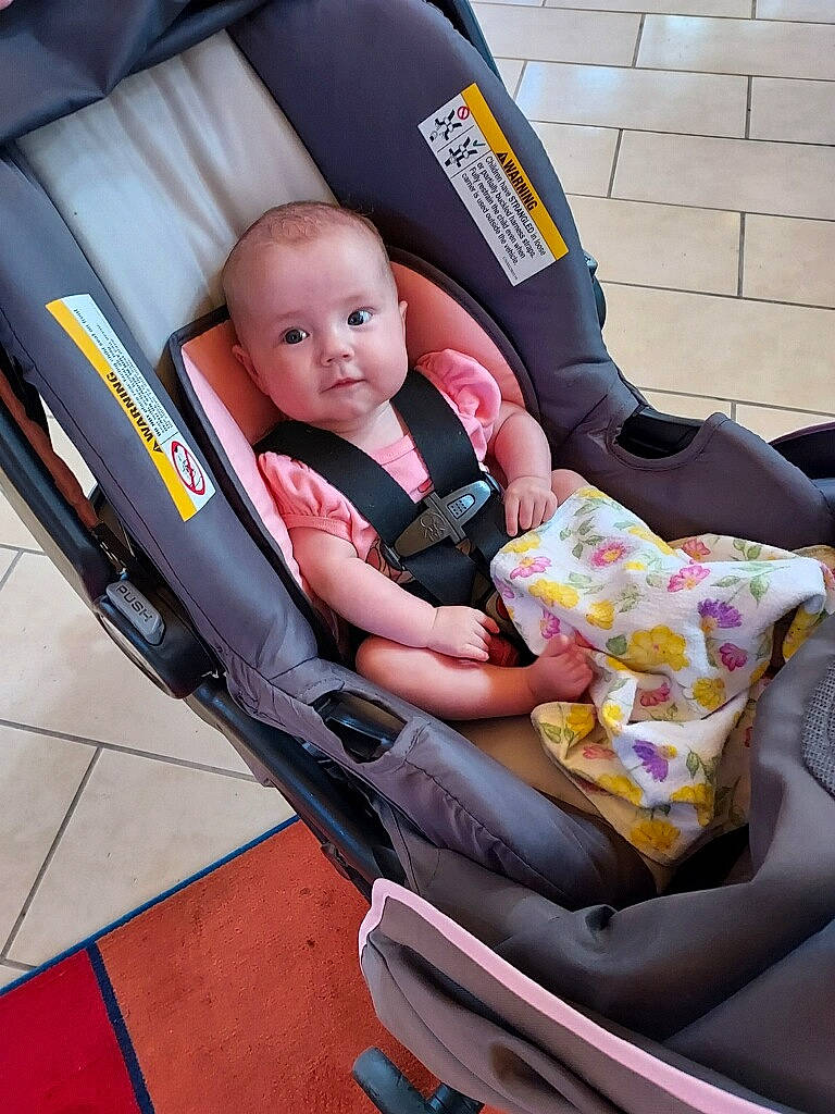 Oaklynn is registered to the contest to win money with this photo: auto_part, automotive_design, baby, baby_carriage, baby_products, baby_safety, baby_toddler_clothing, car_seat, carmine, chair, child, comfort, fun, lap, motor_vehicle, person, personal_protective_equipment, product, sitting, toddler