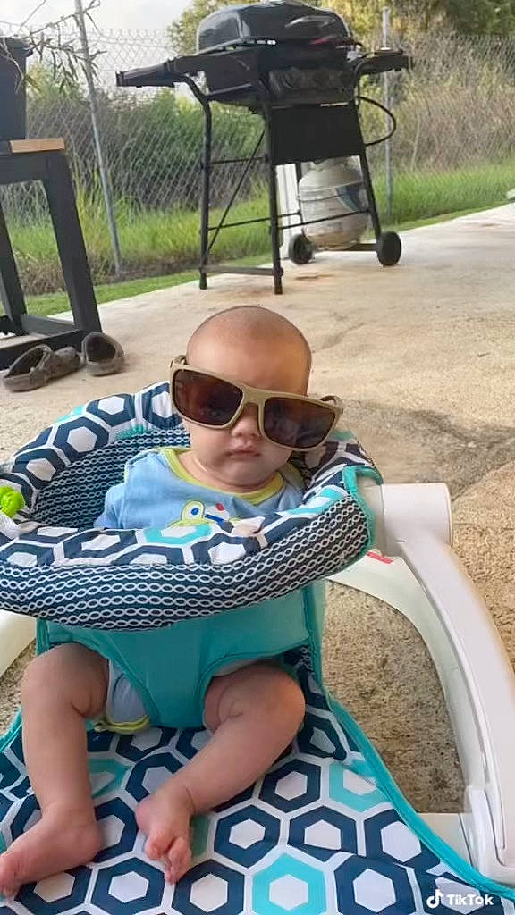 Brian is registered to the contest to win money with this photo: baby_toddler_clothing, eyewear, goggles, grass, green, lap, leisure, outdoor_furniture, person, personal_protective_equipment, plant, product, public_space, recreation, shoe, shorts, summer, sunglasses, thigh, vision_care