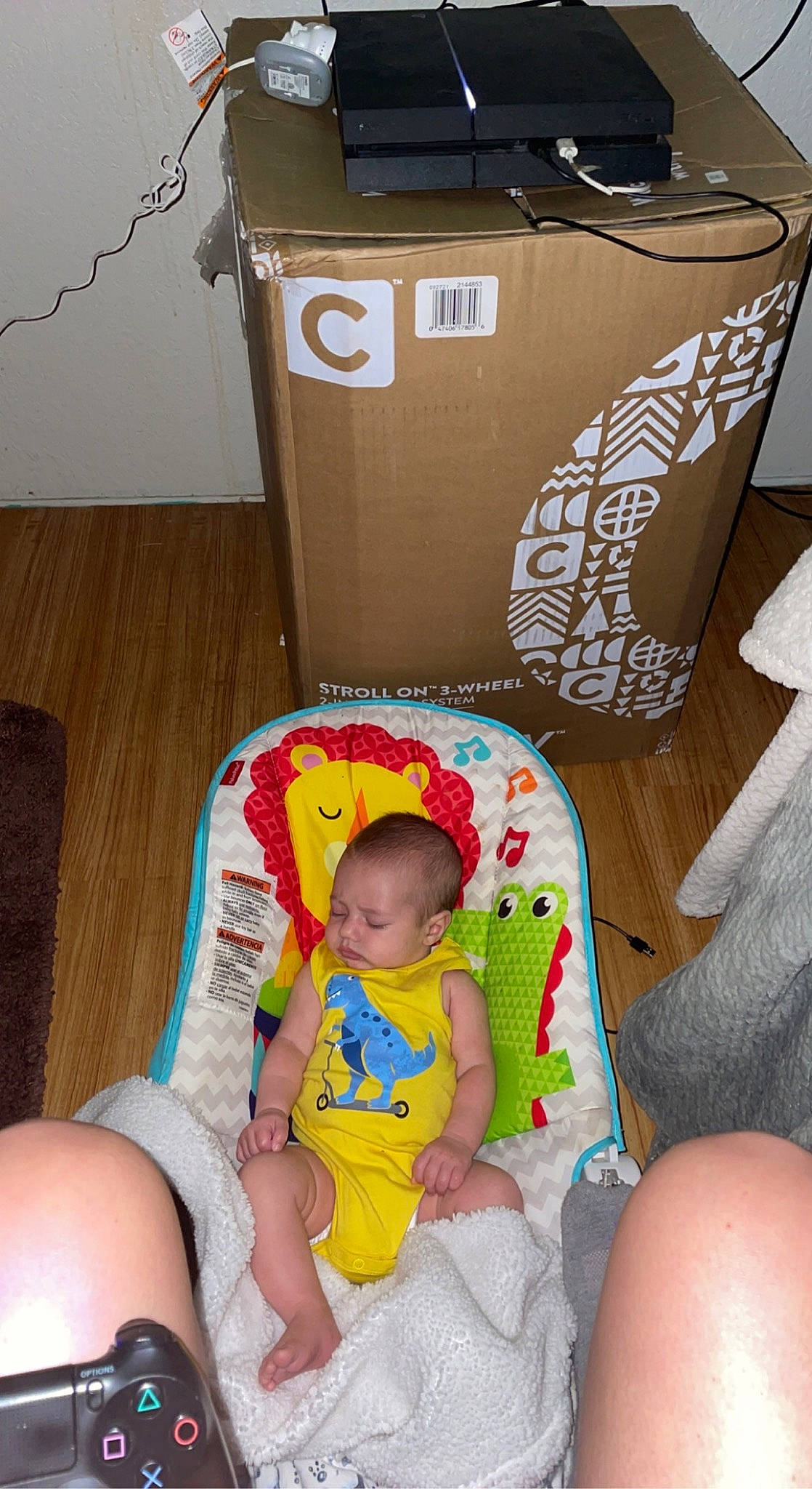Brian is registered to the contest to win money with this photo: baby, baby_toddler_clothing, box, carton, chair, child, comfort, flooring, foot, fun, human_leg, lap, person, room, shipping_box, sitting, sock, sorrow, thigh, toddler