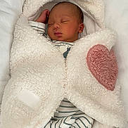 Ismaïl participe au concours pour gagner de l'argent avec cette photo : baby, newborn, sleeping, blanket, fluffy, heart, striped_clothing, infant, cute, soft, cozy, child, resting, wrapped, peaceful, indoors, portrait, sleep, warm, adorable