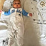Ismaïl a rejoint le concours — aidez-le/la à gagner de superbes lots ! baby, infant, onesie, milestone_blanket, months, jordan, blue_sleeves, lying_down, cute, face, head, arms, fingers, feet, white_blanket, numbers, marker, wood_floor, indoor, portrait