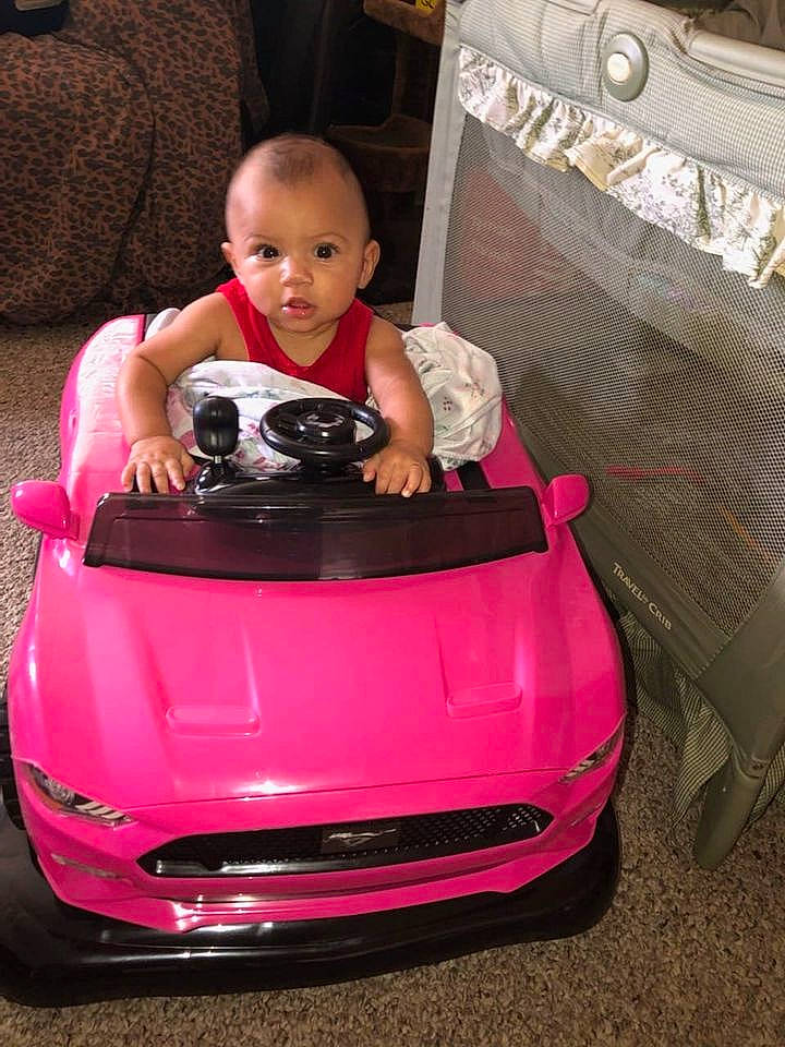 Journee is registered to the contest to win money with this photo: auto_part, automotive_design, automotive_exterior, automotive_lighting, automotive_tire, automotive_wheel_system, bumper, car, child, happy, hood, magenta, motor_vehicle, person, personal_luxury_car, pink, riding_toy, tire, toddler, vehicle