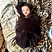 Julia a rejoint le concours — aidez-le/la à gagner de superbes lots ! baby, child, blanket, hood, wrapped, tiger_print, bed, bedding, pattern, fur_texture, soft, cute, face, eyes, mouth, person, indoor, portrait, lying_down, warm