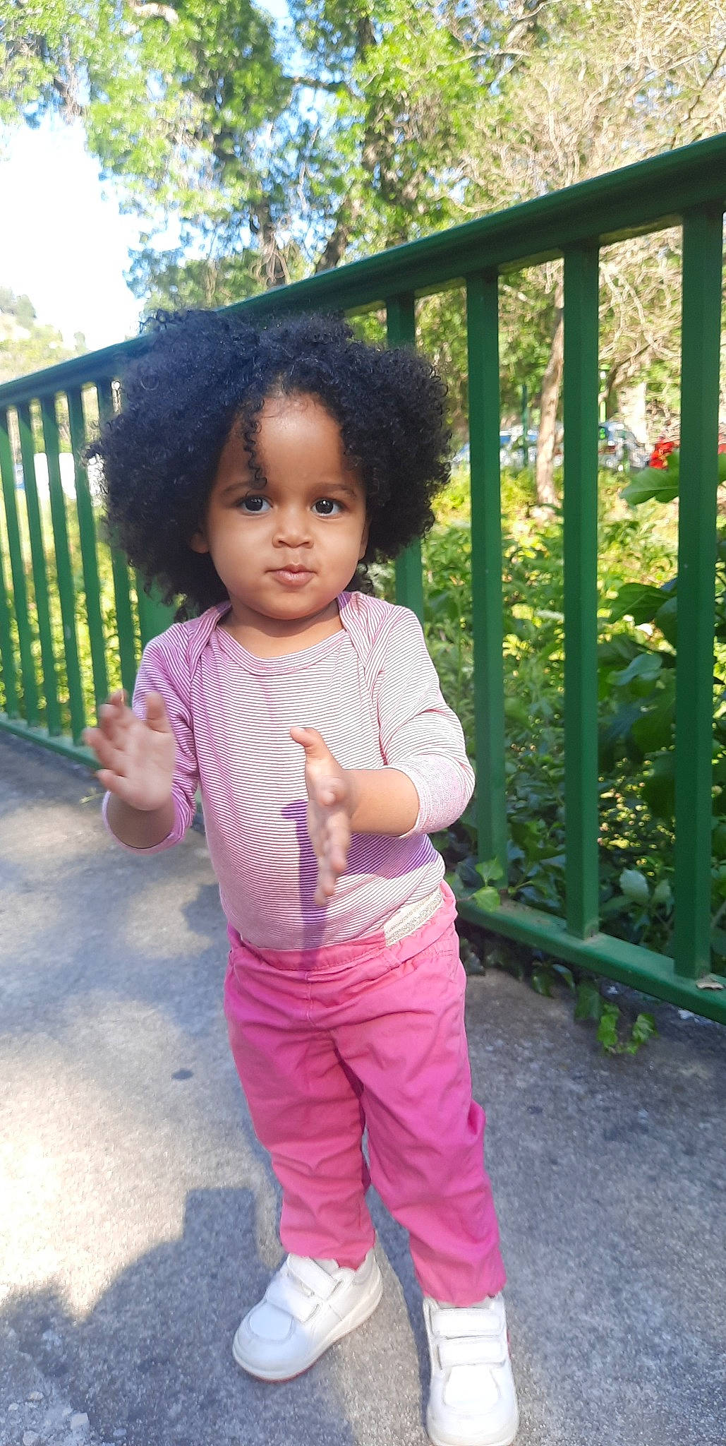 Angelina a rejoint le concours — aidez-le/la à gagner de superbes lots ! baby_toddler_clothing, cheek, chin, eye, face, facial_expression, fence, grass, hair, happy, head, leaf, nose, people_in_nature, person, pink, plant, skin, sleeve, toddler