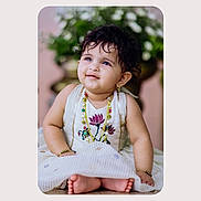 Adrika joined the competition — help win amazing prizes! baby, child, curly_hair, jewelry, dress, sitting, smiling, portrait, indoor, flower_embroidery, cute, happy, skin, feet, bracelet, earrings, necklace, person, background, photography