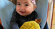 Anaïa participe au concours pour gagner de l'argent avec cette photo : baby, baby_chair, child, clothing, cute, face, hands, happy, headband, indoor, infant, patterned_pants, person, pink_bow, playful, plush_toy, seated, smiling, toy, yellow_toy