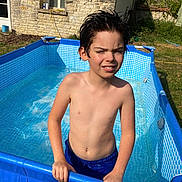 Issa participe au concours pour gagner de l'argent avec cette photo : backyard, blue_trunks, boy, child, daylight, fun, grass, hands, outdoor, person, pool, recreation, squinting, stone_wall, summer, sunlight, swimming, warm_weather, water, wet_hair