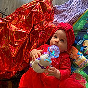 Sileyna participe au concours pour gagner de l'argent avec cette photo : baby, blue_eyes, child, colorful, curious, cute, face, festive, floor, glowing_toy, hands, headband, indoor, infant, knitted_blanket, lying_down, playmat, red_clothing, toy, wrapping_paper