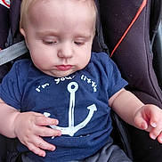 Noha participe au concours pour gagner de l'argent avec cette photo : anchor_design, baby, blue_shirt, calm_expression, car_seat, casual_clothing, child, cute, indoor, infant, light_blonde_hair, looking_down, photography, portrait, seatbelt, shorts, sitting, small_hands, soft_lighting, young_child