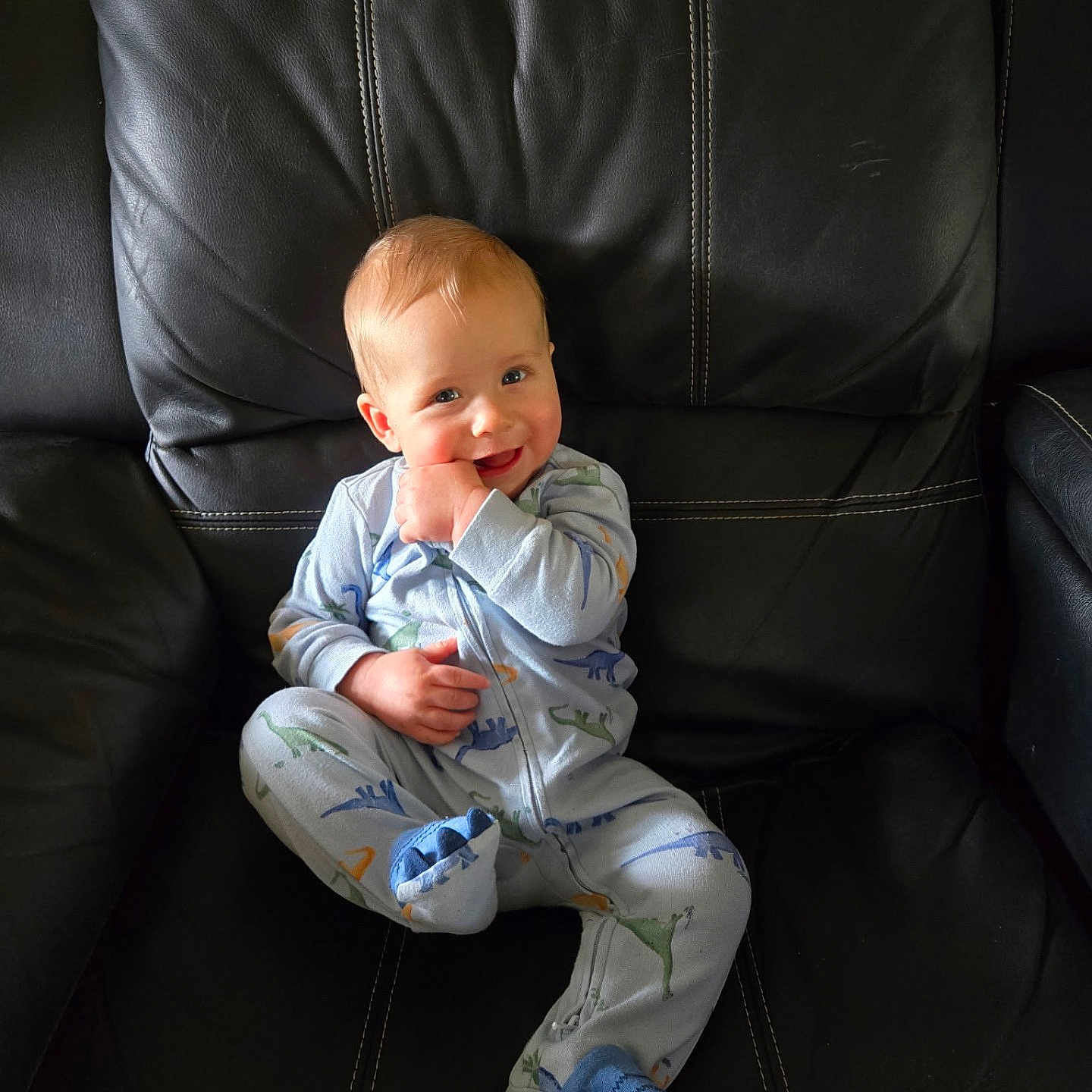 Charles joined the competition — help win amazing prizes! baby, black_leather_chair, casual, child, comfort, cozy, cute, dinosaur_print, footed_pajamas, happy, indoor, infant, onesie, person, playful, portrait, seated, sitting, smiling, young_child