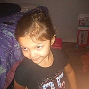 Camila joined the competition — help win amazing prizes! child, smiling, indoor, bed, bedding, purple, black_shirt, number_95, sparkles, face, hair, play_kitchen, floor, toy, person, young, girl, room, furniture, casual