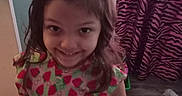 Camila is registered to the contest to win money with this photo: child, colorful, curtain, dress, floor, girl, hair_ties, happy, home, indoor, long_hair, patterned_clothing, person, playful, portrait, smile, standing, wood_floor, young_child, zebra_pattern