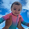 Kennedy joined the competition — help win amazing prizes! baby, child, infant, smiling, portrait, outdoor, sky, clouds, blue_sky, onesie, pink_clothing, colorful_clothing, being_held, adult_hands, family, happy, face, eyes, sunlight, vertical_photo