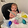 Ashton is registered to the contest to win money with this photo: baby, high_chair, paint, plastic_bags, paper_towels, smiling, indoor, child, art_project, messy, face, seatbelt, white_wall, door_handle, table, fun, colorful, happy, young_child, painting