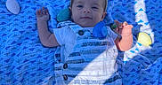 Ashton joined the competition — help win amazing prizes! baby, bunny_ears, blue_blanket, plastic_eggs, grass, outdoor, sunlight, shade, baby_clothes, striped_overalls, white_shirt, smiling, face, infant, playtime, spring, easter_theme, cute, child, lying_down