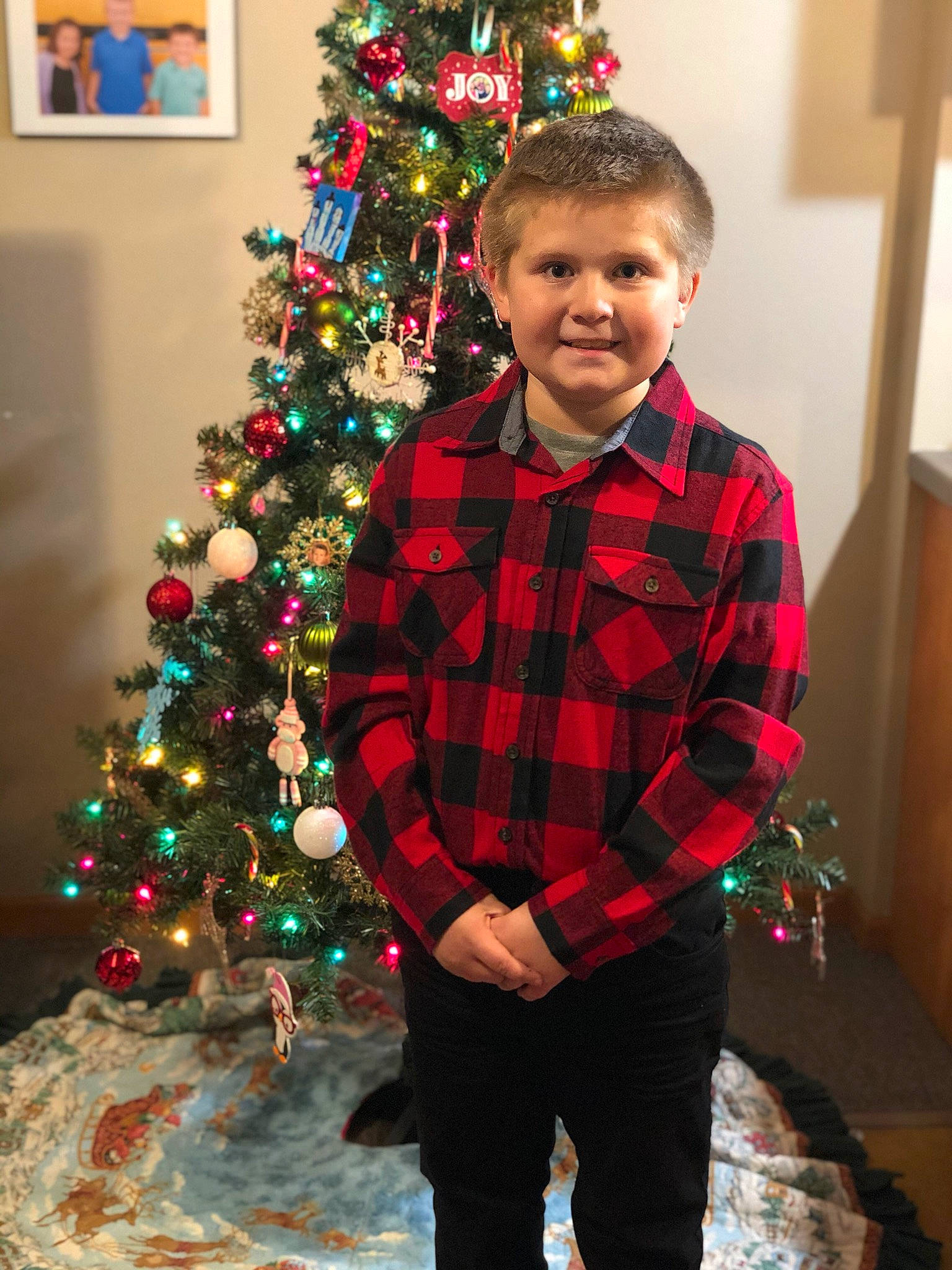 Jayce is registered to the contest to win money with this photo: child, christmas, christmas_decoration, christmas_eve, christmas_ornament, christmas_tree, design, event, holiday, holiday_ornament, home, interior_design, joy, outerwear, pattern, person, plaid, plant, standing, toddler