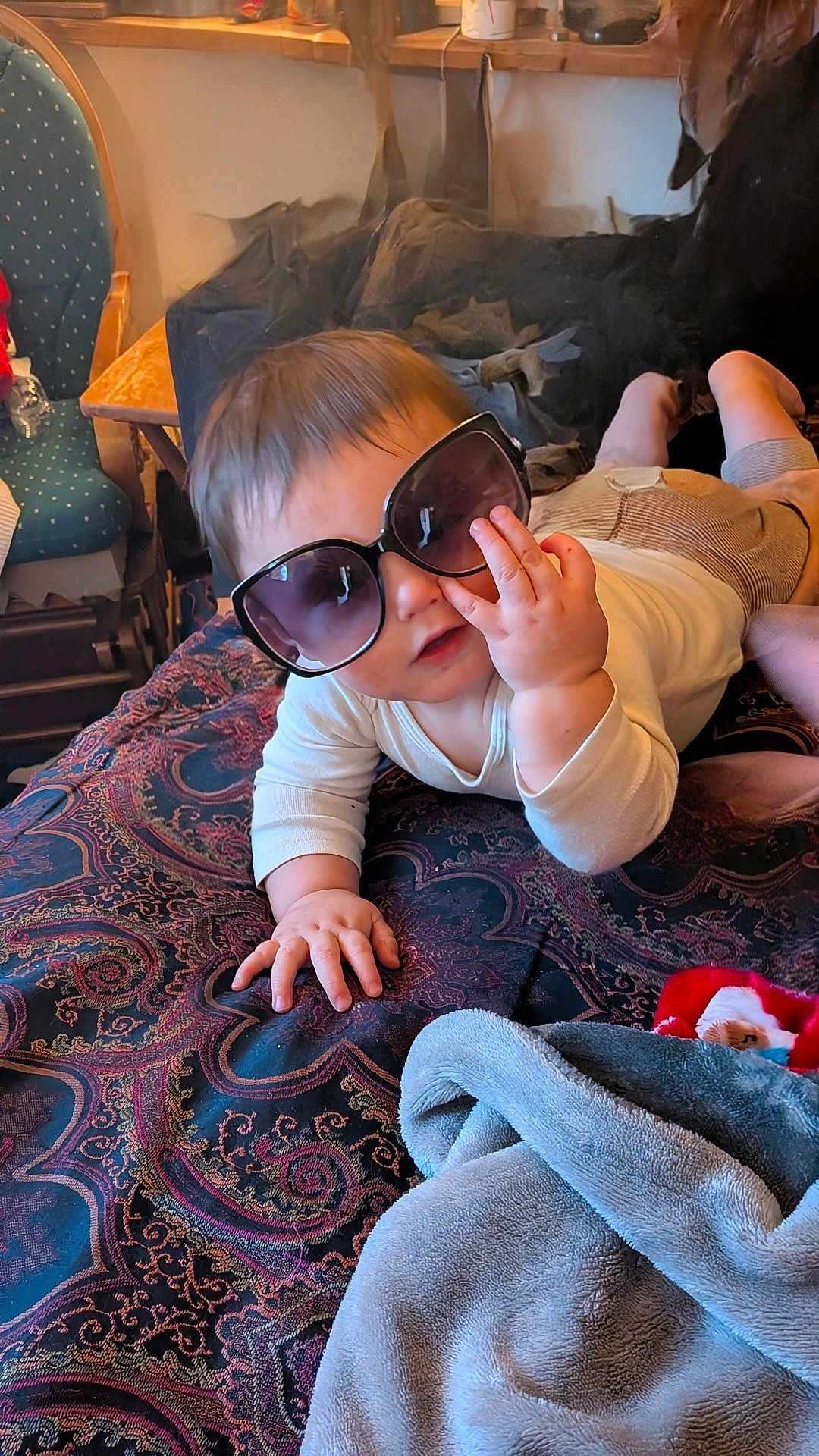 Giovonny is registered to the contest to win money with this photo: baby, sunglasses, blanket, indoor, child, hand, face, furniture, chair, pattern, clothing, person, cute, portrait, toddler, soft, cozy, relaxed, infant, home