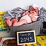 Julianna joined the competition — help win amazing prizes! baby, basket, glasses, headband, blanket, books, chalkboard, sign, measuring_tape, feet, fingers, clothing, indoor, child, cute, portrait, soft_texture, colorful, reading, decor